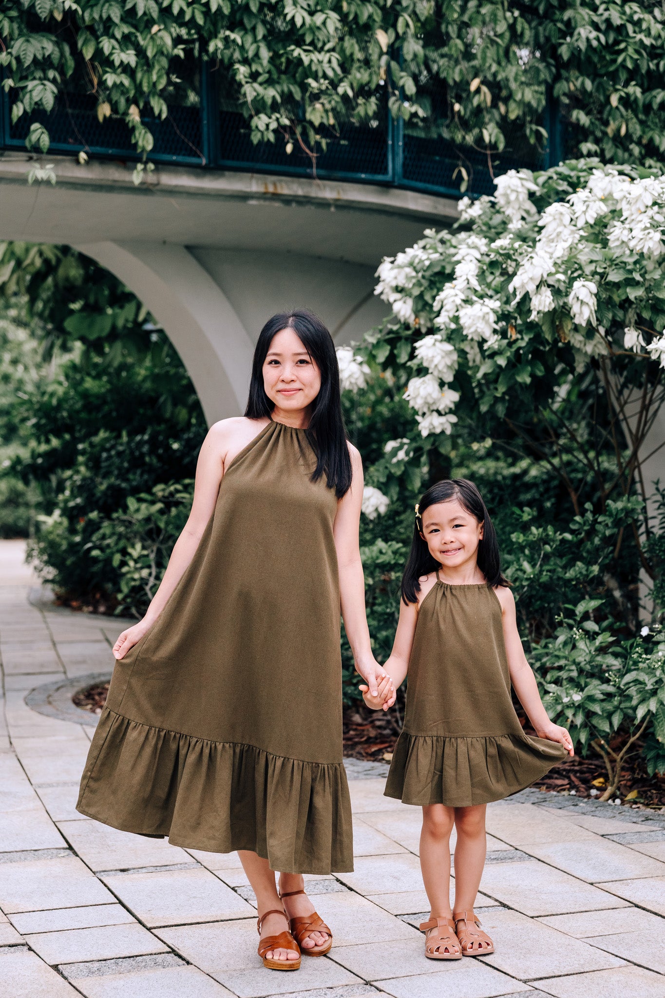 Mother and daughter wearing matching MOSS Isla Dress and Mini Isla Dress in soft moss green linen blend fabric