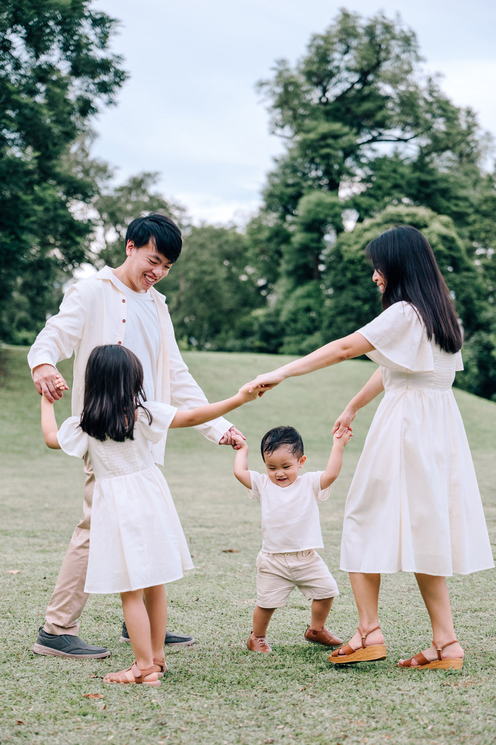 Family wearing coordinated SAND Collection linen outfits in soft neutral tones