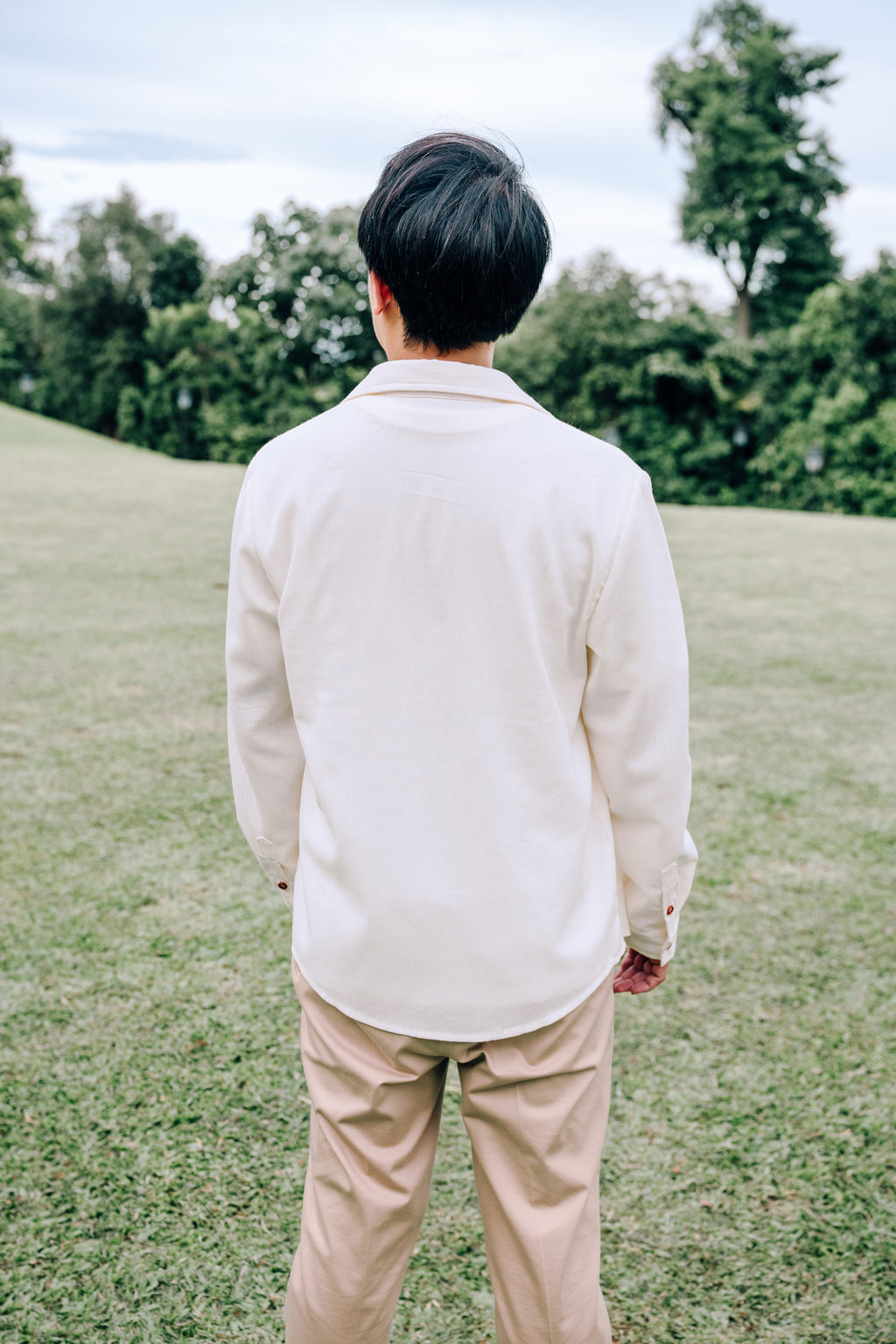 Back view of man wearing SAND Elio Shirt in breathable sand linen blend