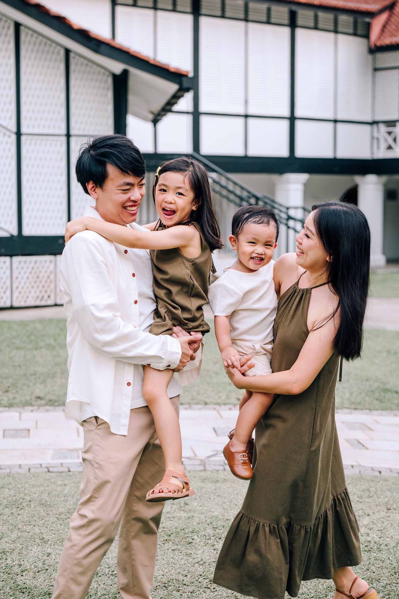 Family wearing coordinated SAND and MOSS Collection outfits featuring Elio Shirt, Mini Noa T-Shirt, Isla Dress and Mini Isla Dress
