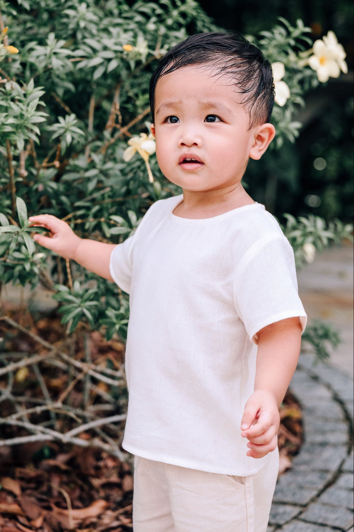 Child wearing SAND Mini Noa T-Shirt in neutral tone sand linen blend fabric