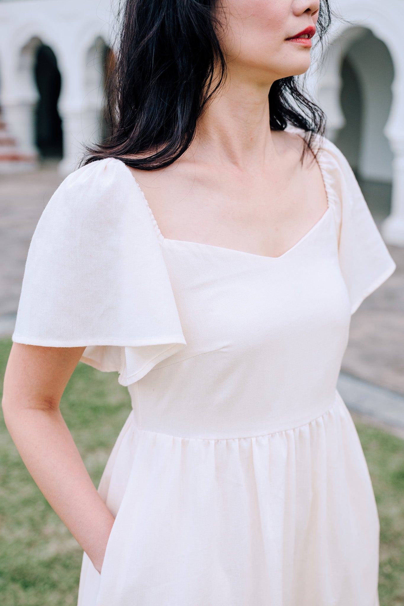 Close-up of SAND Mira A-Line Dress smocked back and ruffle sleeves in sand