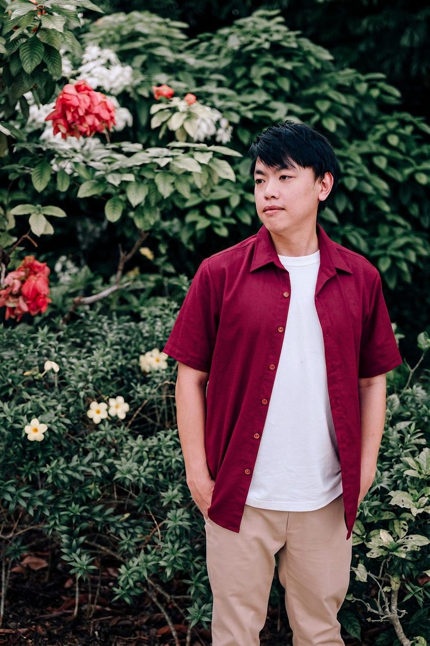 A man wearing a burgundy short-sleeve button-up linen shirt.