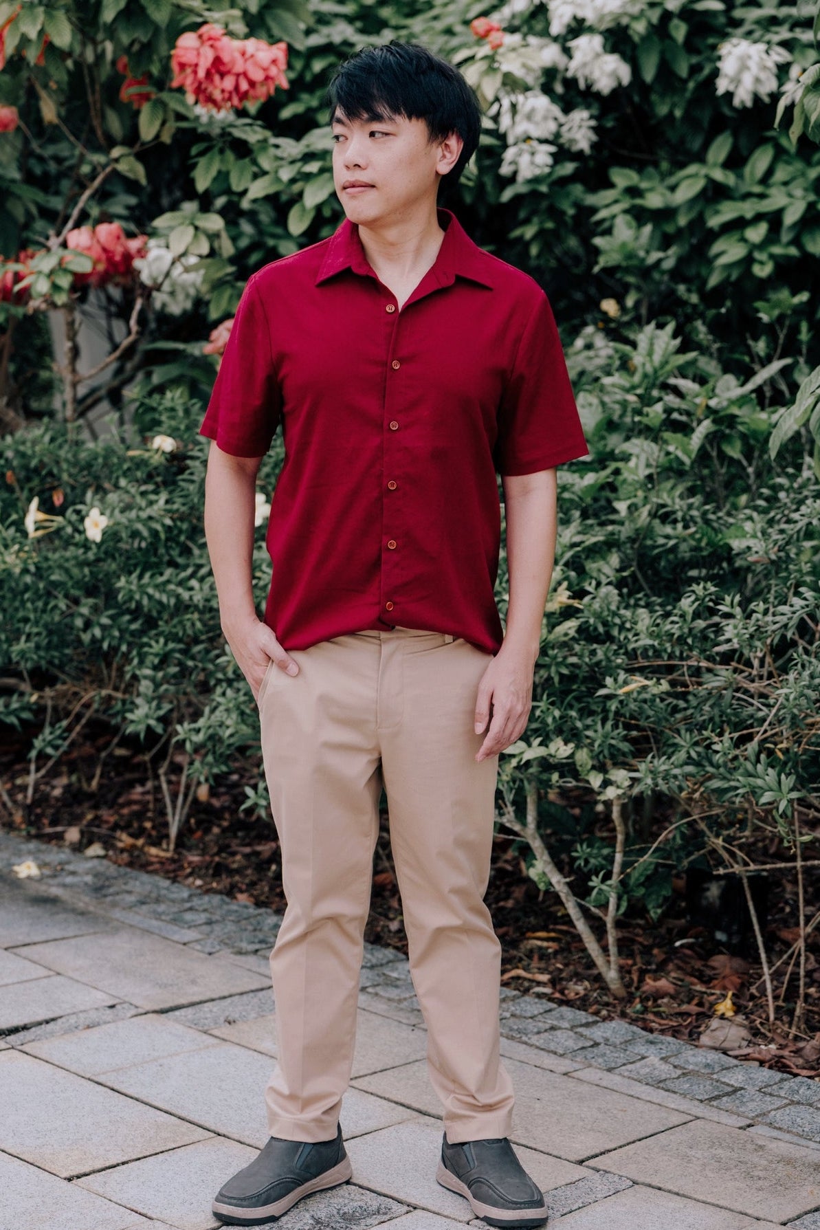 A man wearing a short-sleeve burgundy button-up linen shirt.