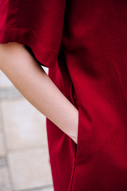 Close-up of hands inside burgundy linen dress pocket