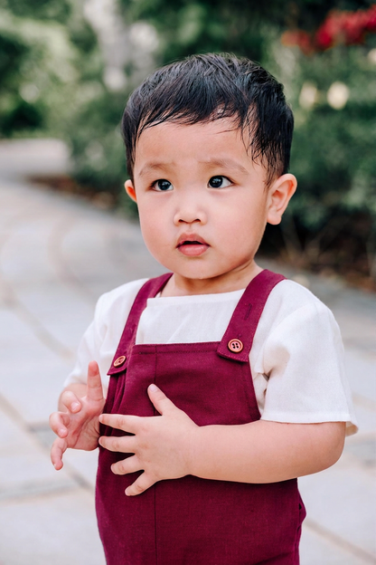 Boy wearing burgundy linen dungaree with sand beige tee