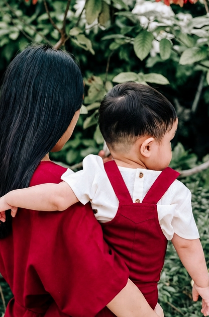 Back view of Mother and Child in matching burgundy linen dress and linen dungaree.